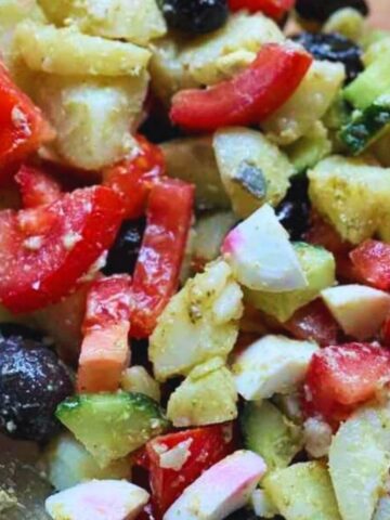 Fresh potato salad with boiled eggs, cucumber, tomato, and olives, a colorful and healthy Mediterranean-inspired dish.