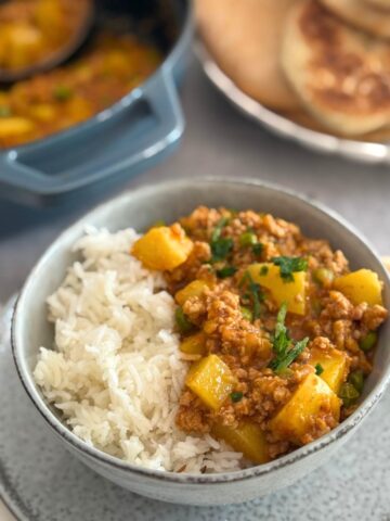 Close-up of creamy Thai coconut turkey potato curry garnished with cilantro.
